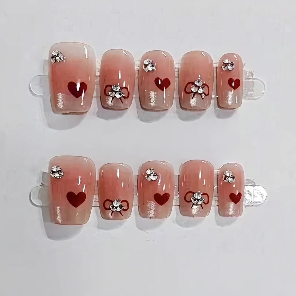 Krótkie kwadratowe tipsy naklejane z francuskim manicure, sercami i kokardkami
