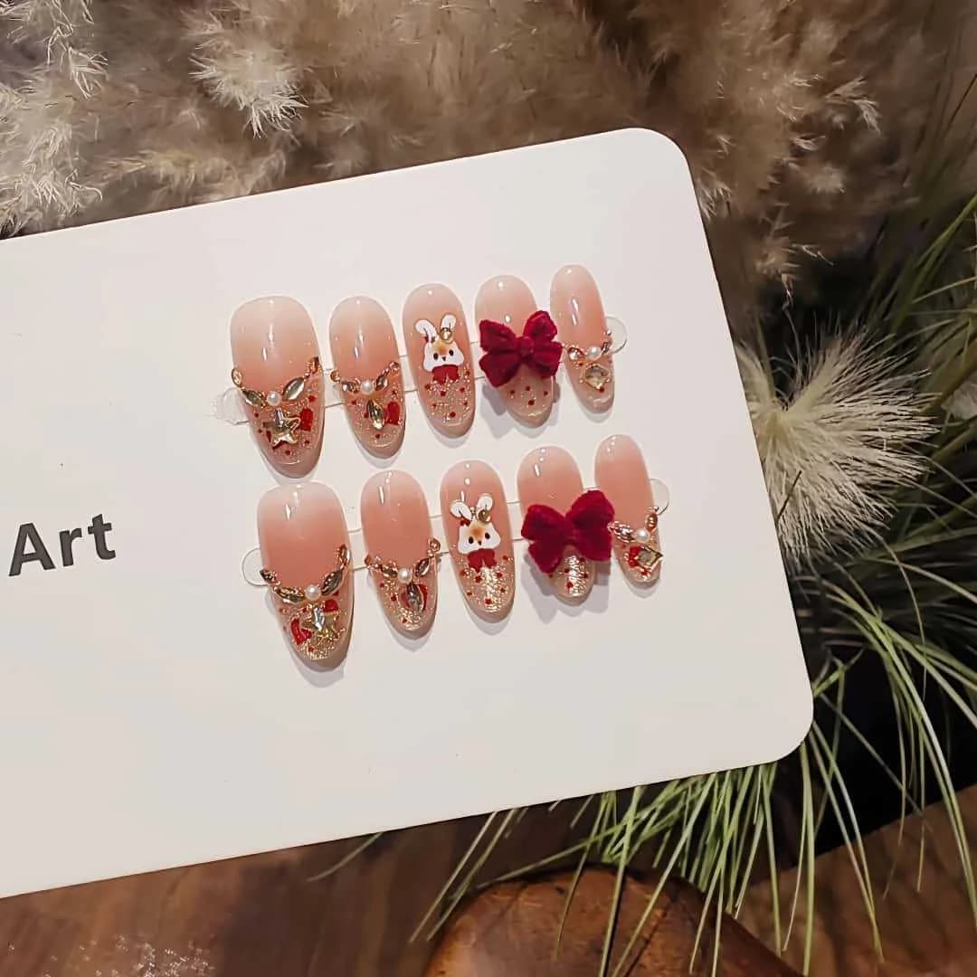 Paznokcie tipsy oval cat eye z francuskimi końcówkami, cyrkoniami i kokardką