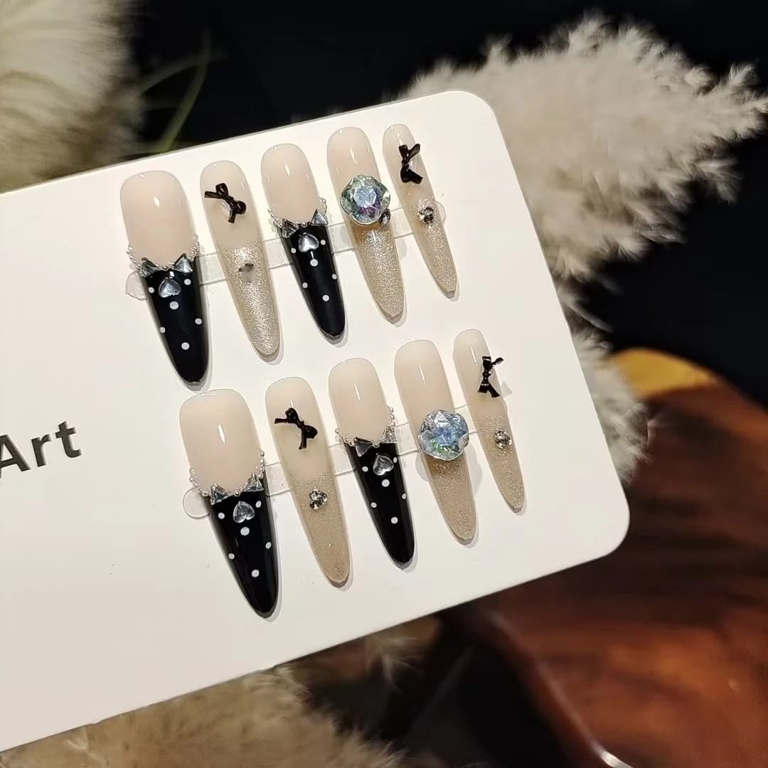 Czarne paznokcie nakładane z motylem i cyrkoniami, manicure Cat Eye z brokatem