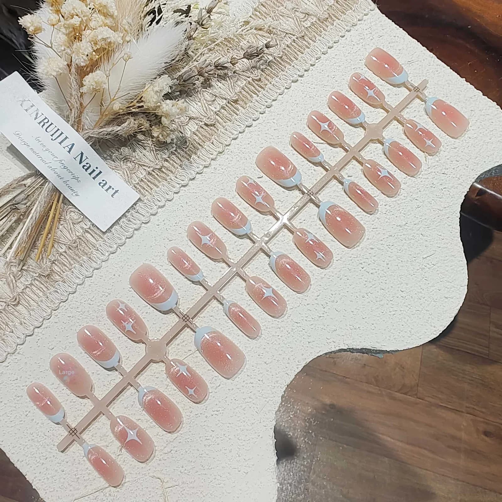 Krótkie owalne paznokcie nakładane Cat Eye, różowy wzór gwiaździstego nieba