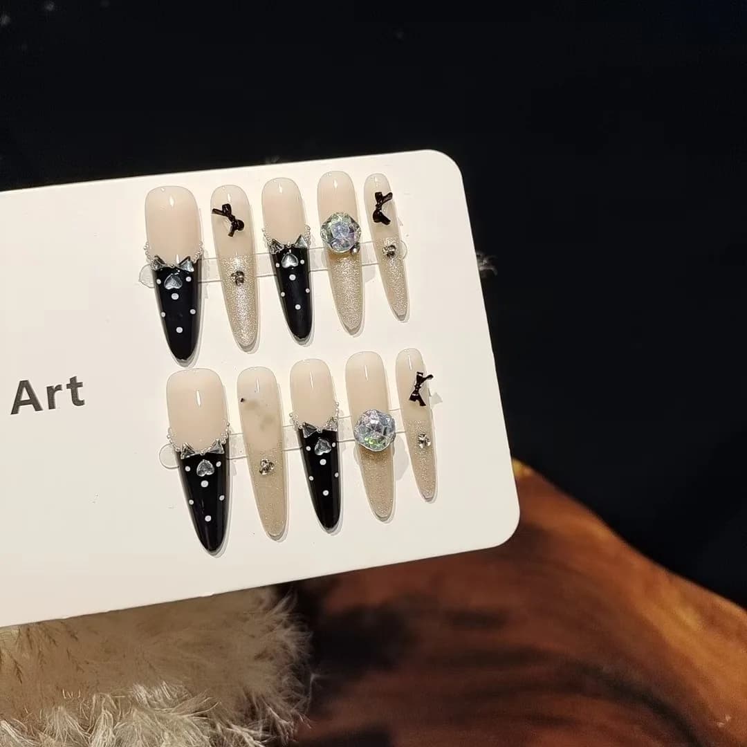 Czarne paznokcie nakładane z motylem i cyrkoniami, manicure Cat Eye z brokatem