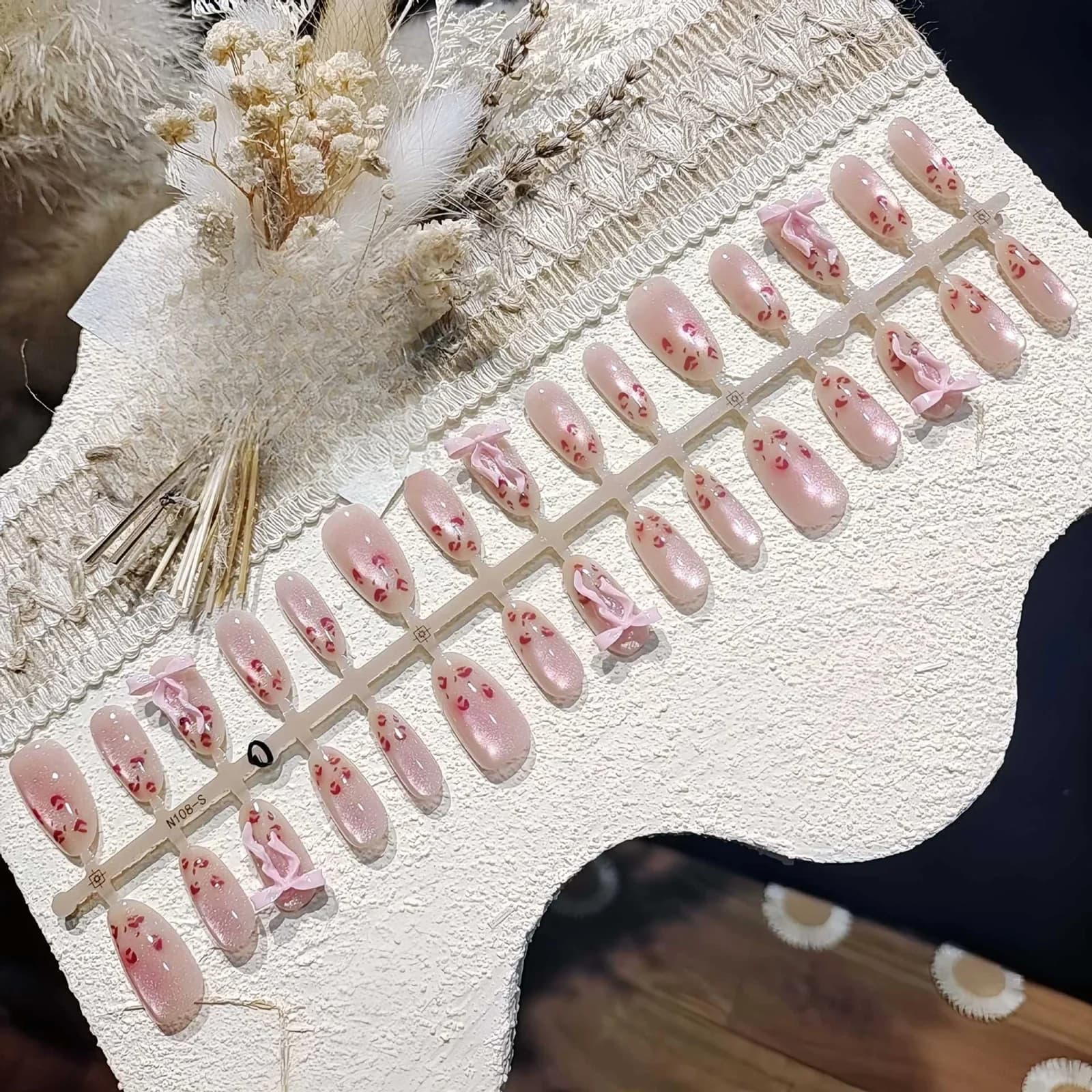 Różowe paznokcie nakładane w cętki lamparta z efektem kociego oka, owalny kształt średni