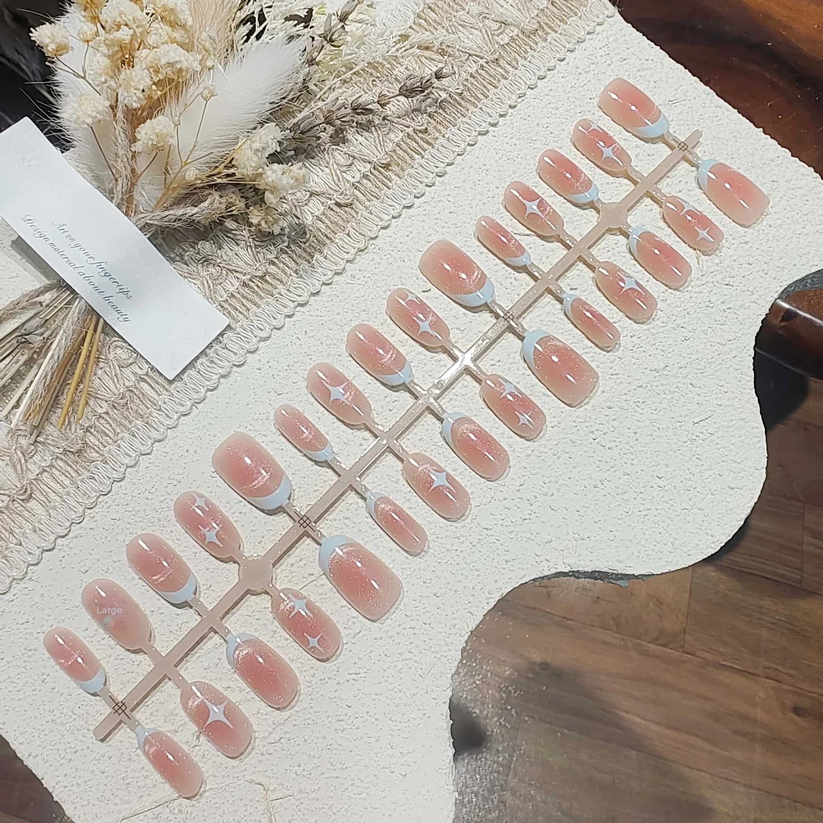 Krótkie owalne paznokcie nakładane Cat Eye z różowym wzorem gwiaździstego nieba